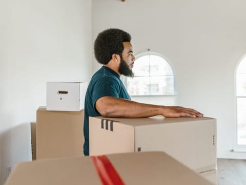 Mitarbeiter räumt Kartons in einem großen, hellen Gewerberaum
